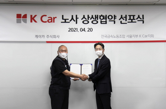 정인국(오른쪽) 케이카 사장과 구자균 금속노조 서울지부 지회장이 지난 20일 노사 상생을 위한 협약식에서 기념사진을 찍고 있다.<케이카 제공>